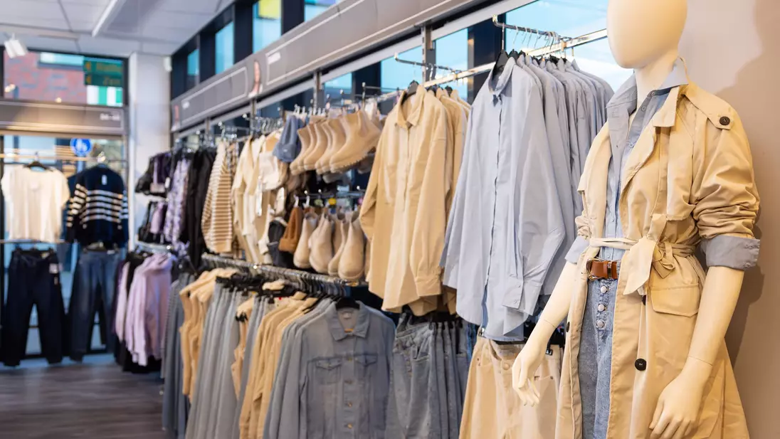 Prezentácia tovaru v kompletných outfitoch na zadnej stene predajne KiK